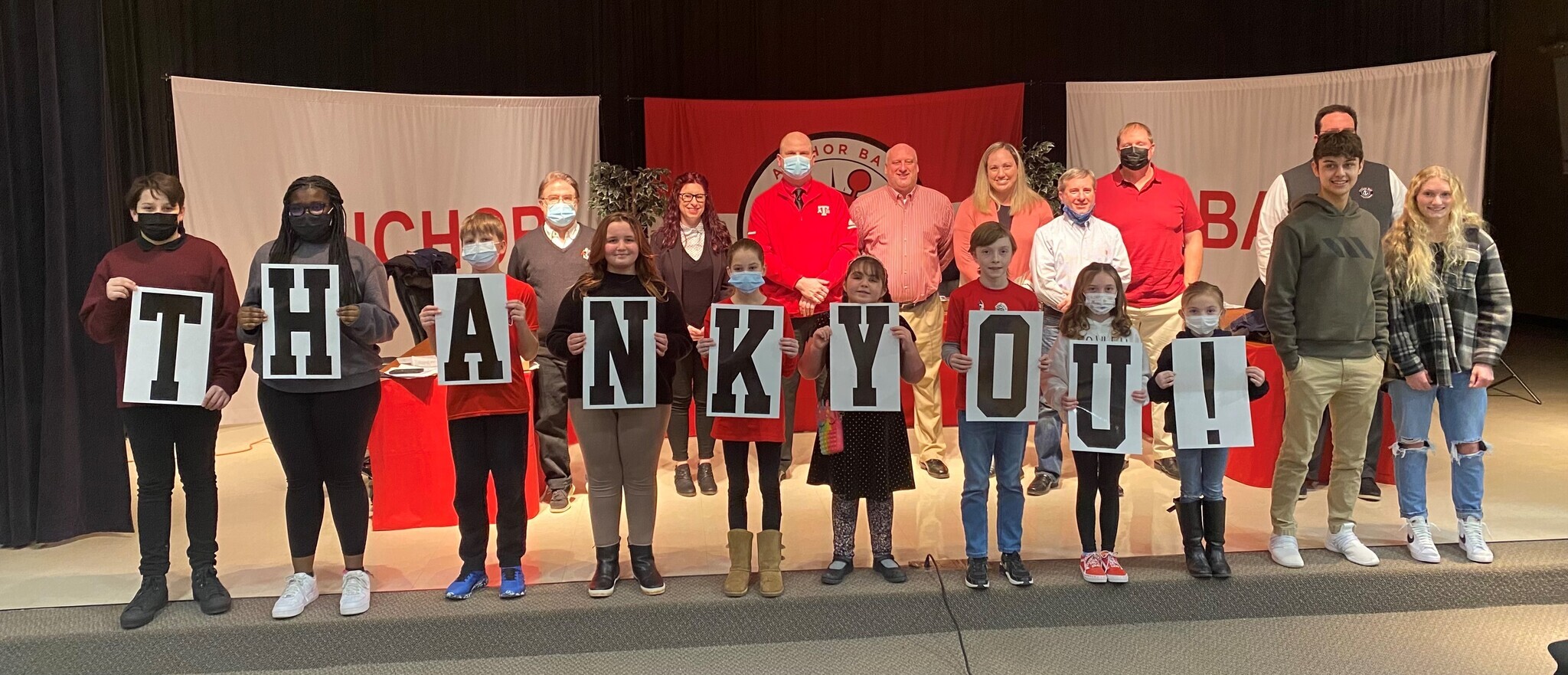 students holding thank you signs in front of board of education photo